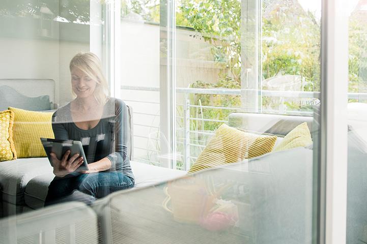 smiling woman using tablet on couch