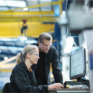 Two people reading information off a computer